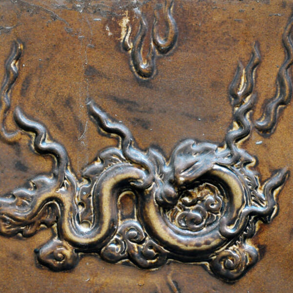 Bas relief, carved brass detail on a bronze backgrounf