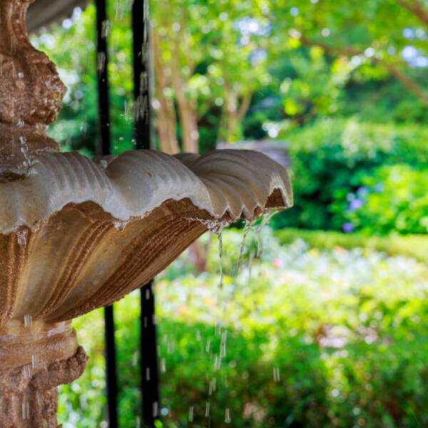Garden with small fountain and benches around Fountain of water drops