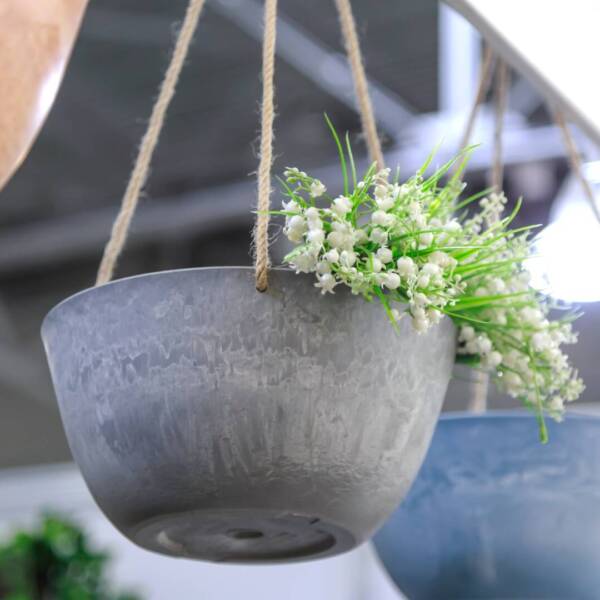 Hanging planter for flowers. Interior design element and garden decor made of natural materials concrete and clay in trendy colors loft style.