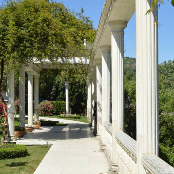 The concept of landscape design in the garden, a beautiful trellis with a column, flowers and trees.
