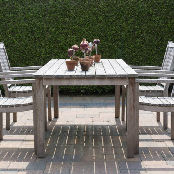 wooden garden furniture in garden with yew hedge